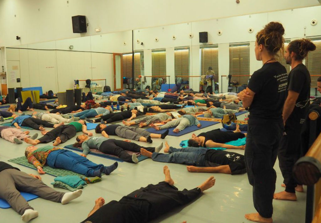 Lezione Feldenkrais con allievi sul pavimento e insegnanti in piedi